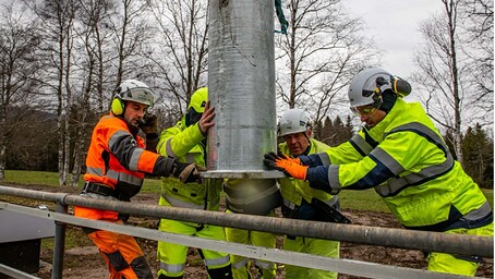 Ouvriers installant un poteau électrique