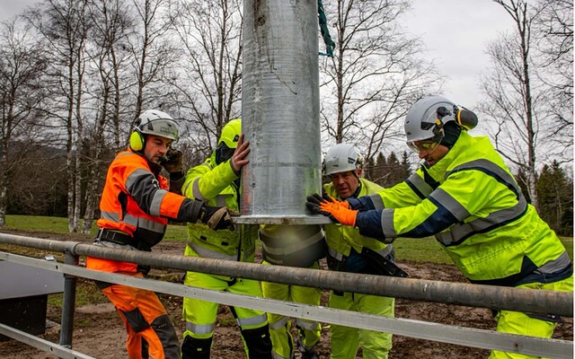 Ouvriers installant un poteau électrique