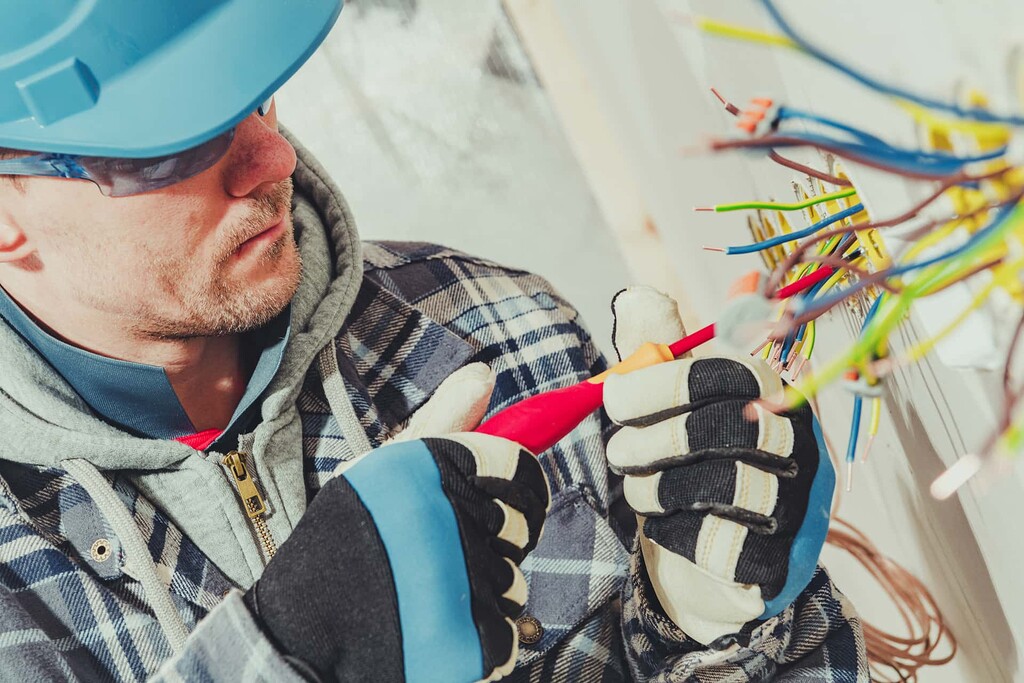 Technicien faisant une installation électrique, un tournevis à la main