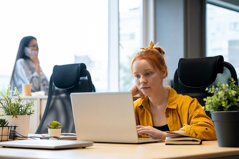 Jeunes femmes rousse travaillant sur son ordinateur portable